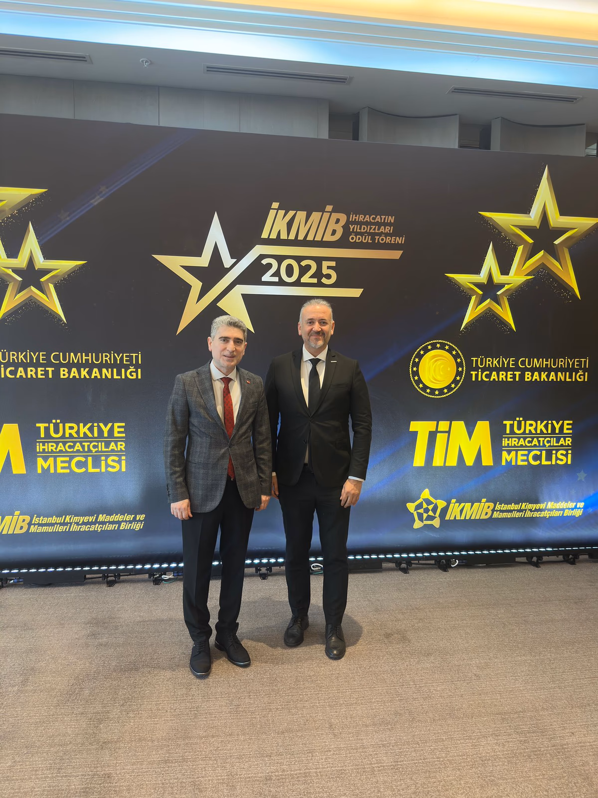 Mustafa Duru et Ömer Karatemiz devant le panneau İKMİB