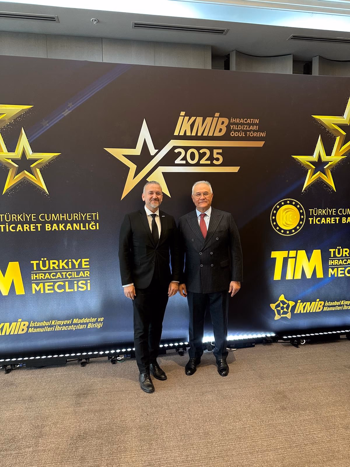 Mustafa Duru et le Président de l'İKMİB devant le décor de la cérémonie